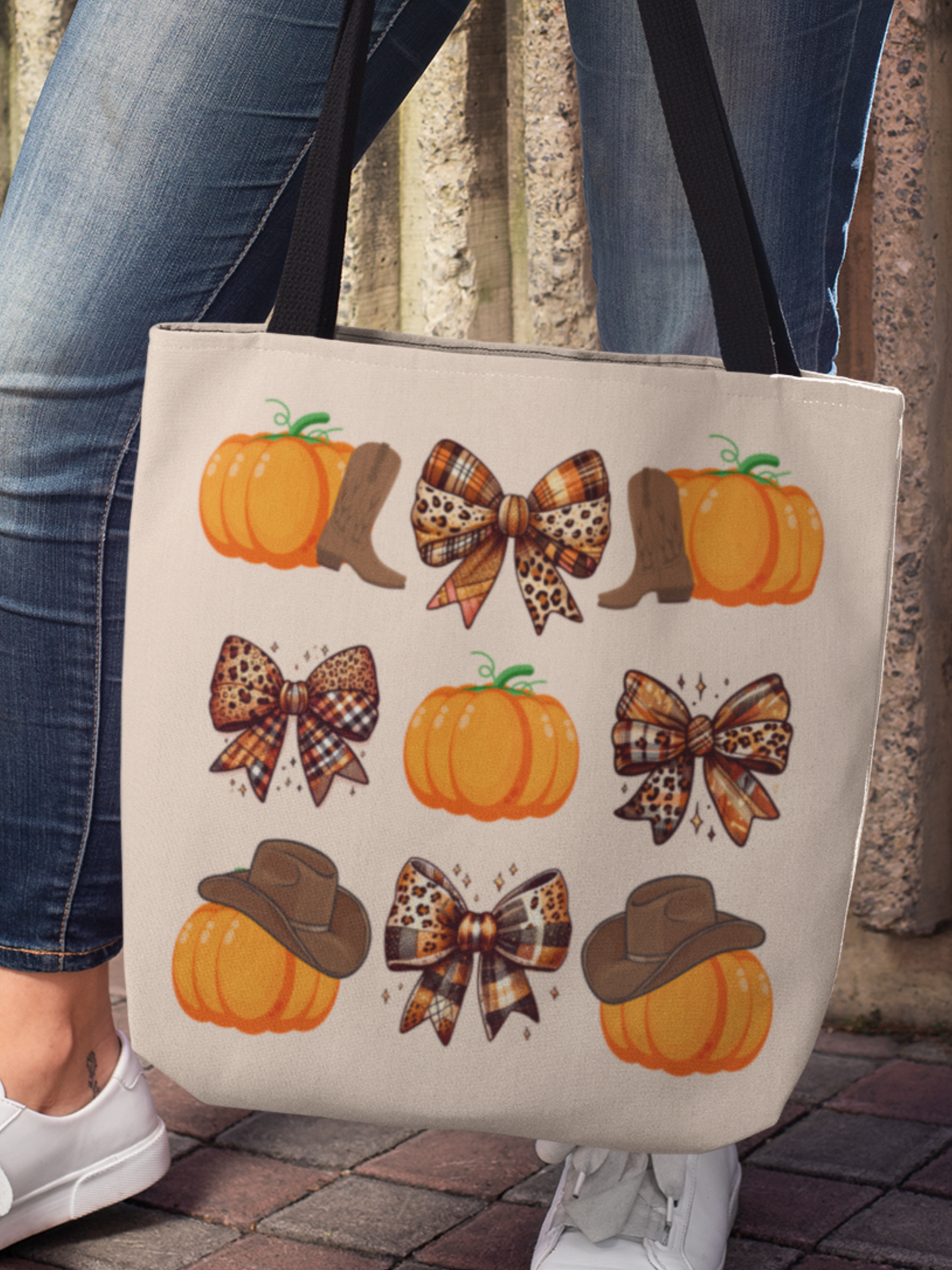 Woman holding a Canvas tote bag with trendy grid print of alternating plaid coquette bows and pumpkins adorned with cowboy boots or cowgirl hats. 